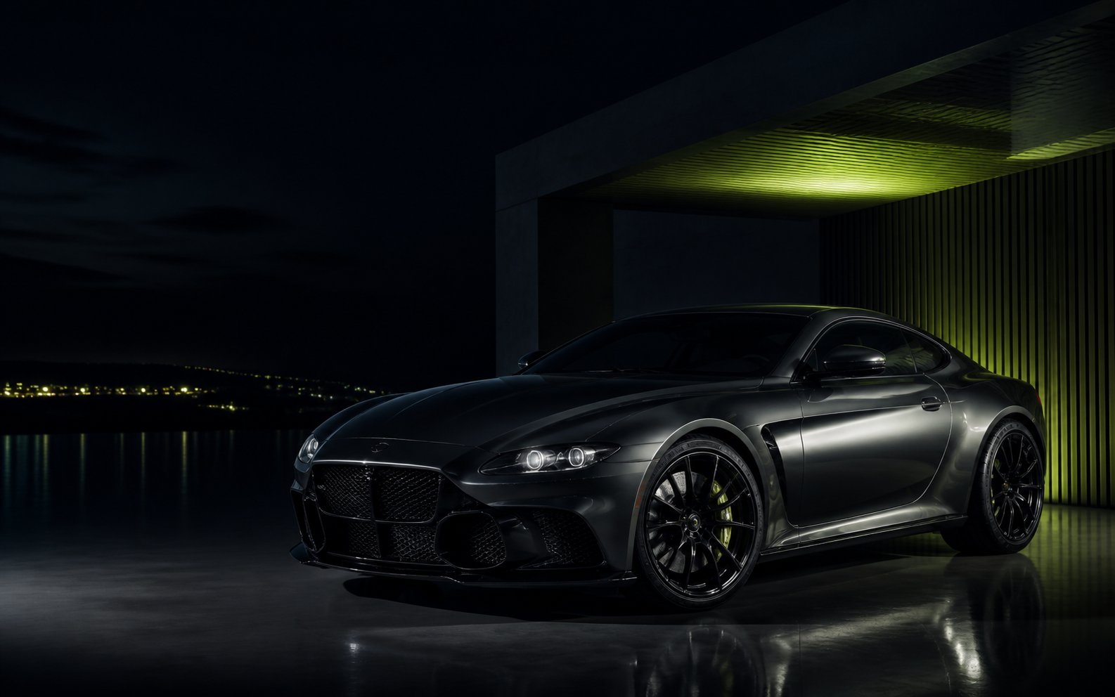A graphite performance car in a dark modern architectural garage